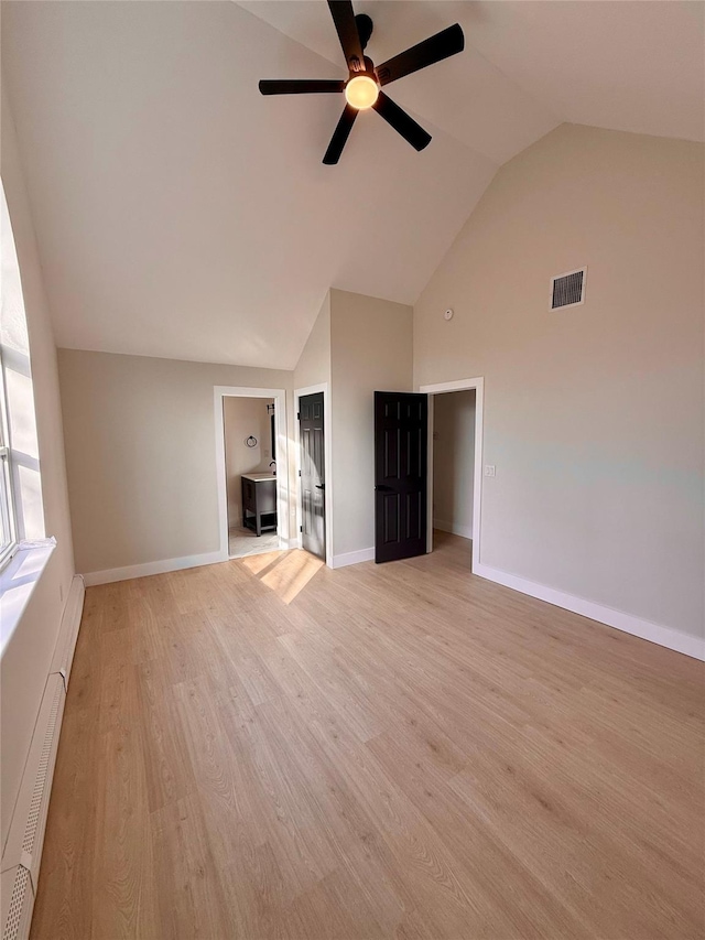 unfurnished living room with ceiling fan, high vaulted ceiling, light hardwood / wood-style floors, and a baseboard heating unit