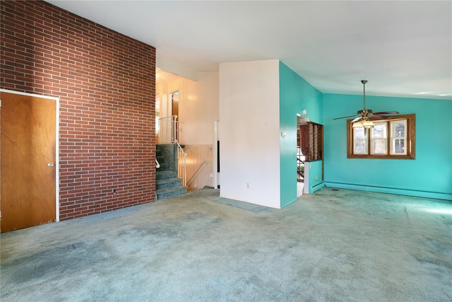 unfurnished living room featuring ceiling fan, baseboard heating, carpet floors, brick wall, and vaulted ceiling