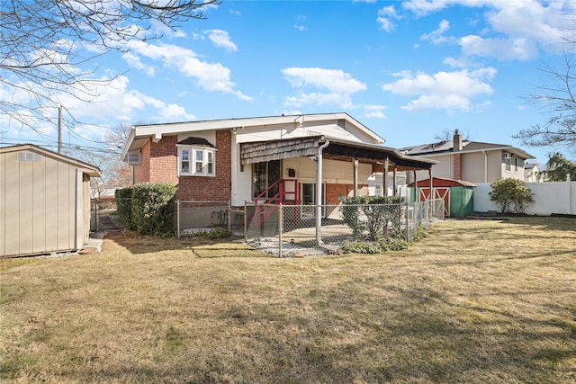 rear view of house with a yard and a storage shed