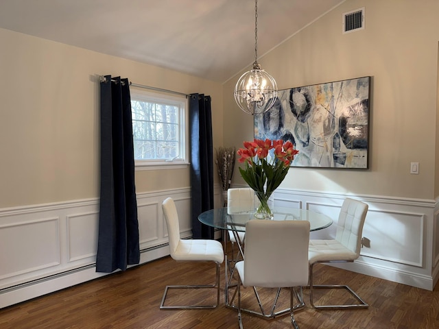 dining area with dark wood-type flooring, baseboard heating, a chandelier, and vaulted ceiling