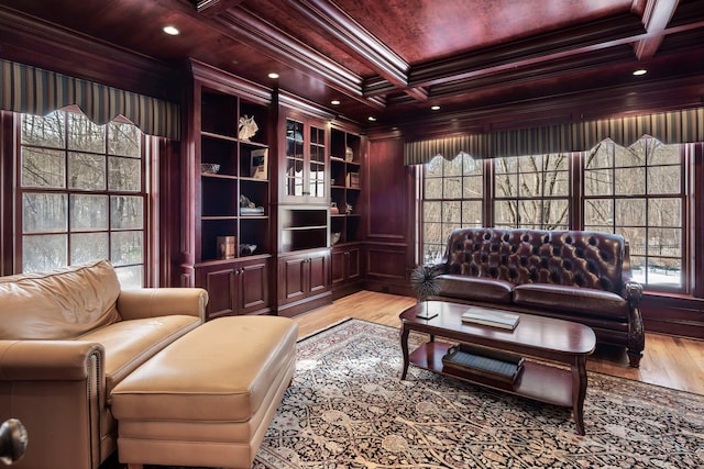 sitting room featuring wooden ceiling, light wood-style flooring, coffered ceiling, ornamental molding, and beam ceiling