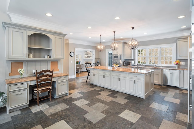 kitchen featuring stainless steel appliances, a center island, light stone countertops, built in desk, and decorative light fixtures