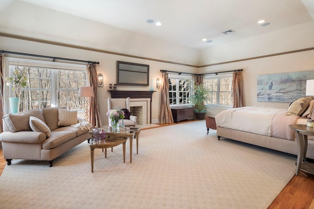 bedroom featuring a fireplace, wood finished floors, visible vents, and recessed lighting