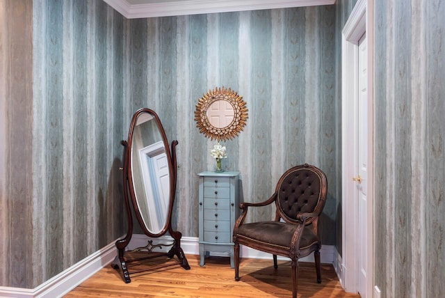 living area with baseboards, wood finished floors, and ornamental molding