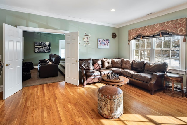 living area featuring ornamental molding, visible vents, and light wood finished floors