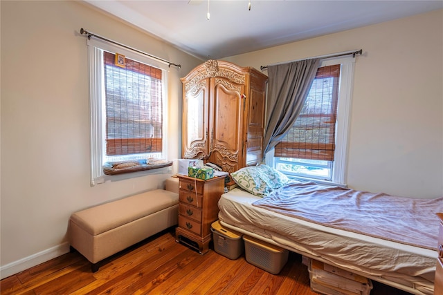 bedroom with hardwood / wood-style flooring and multiple windows