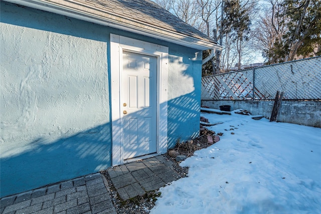 snow covered property with a storage shed