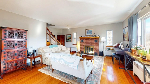 living area featuring hardwood / wood-style floors, radiator, and a wealth of natural light