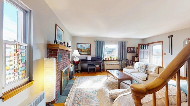 living area featuring radiator, wood finished floors, and a fireplace