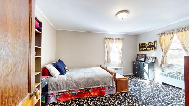 carpeted bedroom with multiple windows, crown molding, and radiator heating unit