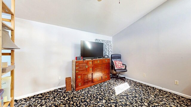 interior space with carpet flooring, baseboards, and lofted ceiling