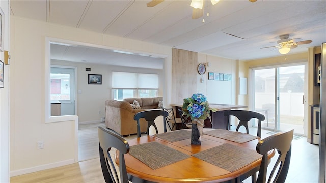 dining area with ceiling fan, baseboards, and light wood-style floors