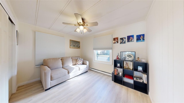 living area featuring a baseboard heating unit, light wood-style flooring, a ceiling fan, and baseboards