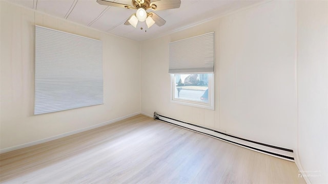 unfurnished room featuring a baseboard heating unit, wood finished floors, baseboards, and a ceiling fan