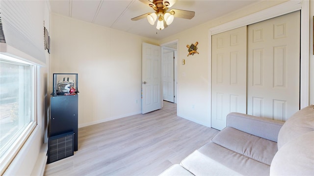 interior space with baseboards, visible vents, a ceiling fan, and light wood-style floors