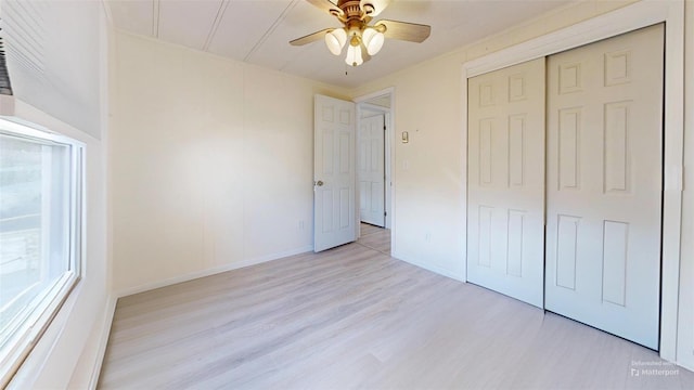 unfurnished bedroom with baseboards, a closet, light wood finished floors, and ceiling fan