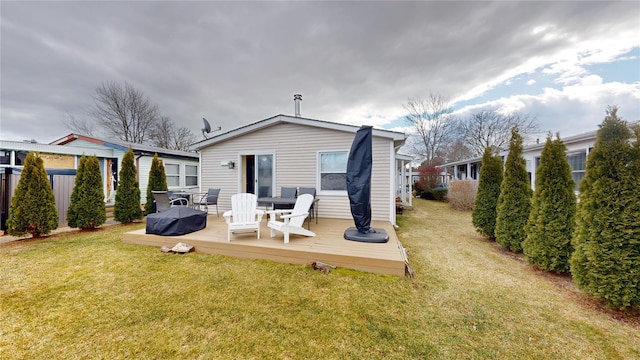 back of house featuring a lawn, fence, and a wooden deck