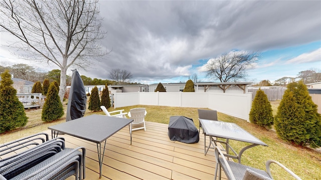 wooden terrace featuring a yard and fence