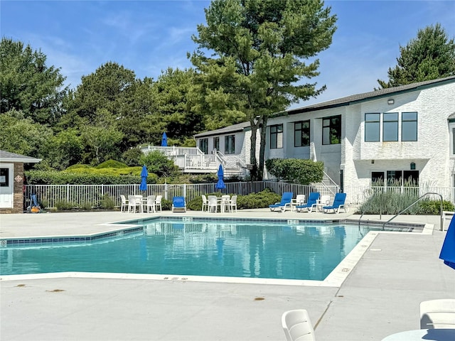 view of swimming pool with a patio and fence