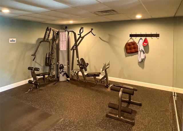 workout room with a drop ceiling, baseboards, and visible vents