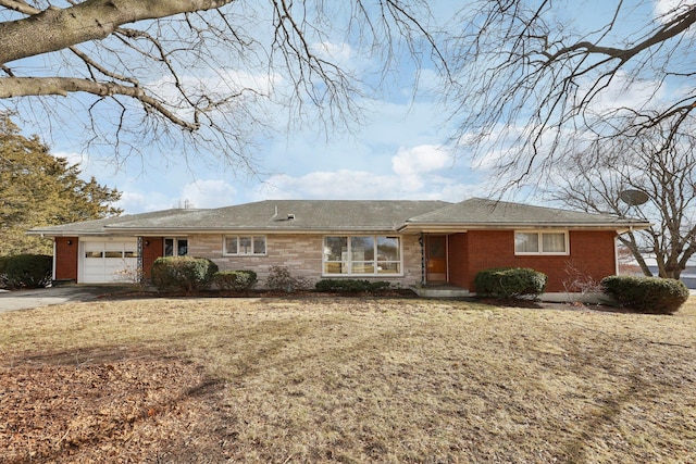 ranch-style home featuring brick siding, driveway, and a garage