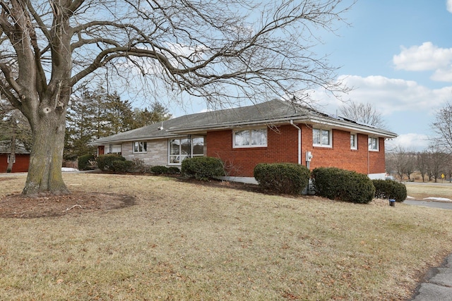 view of side of property featuring brick siding and a lawn