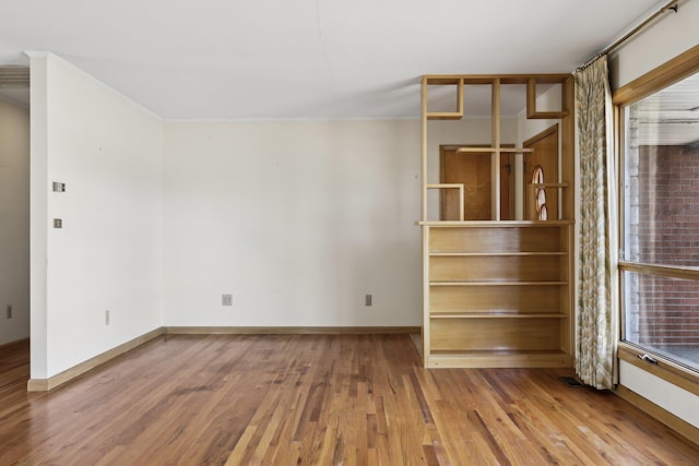 spare room with crown molding, hardwood / wood-style flooring, and a healthy amount of sunlight