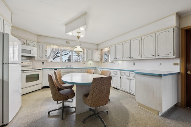 kitchen featuring white cabinetry, white appliances, a kitchen breakfast bar, and sink