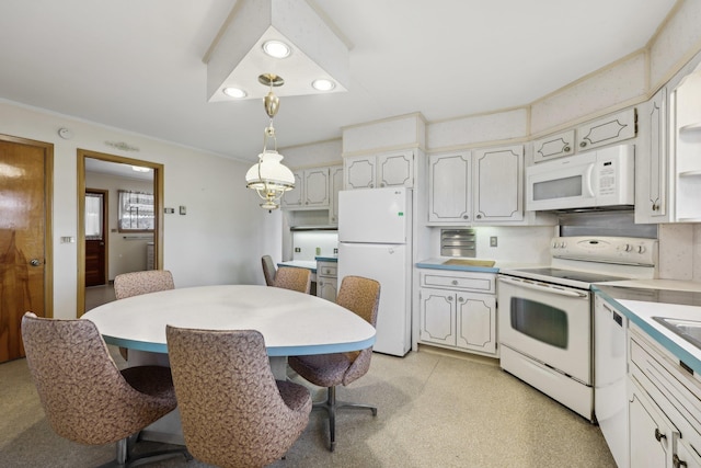 kitchen with white cabinetry, hanging light fixtures, white appliances, and a kitchen bar