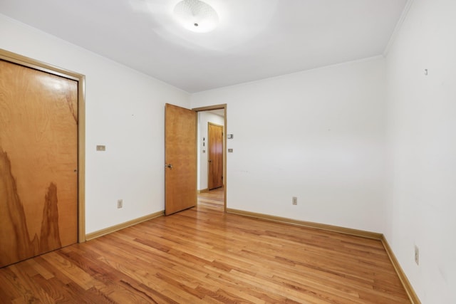 unfurnished room featuring crown molding and light wood-type flooring