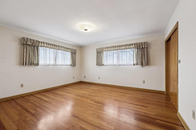 spare room featuring hardwood / wood-style flooring and crown molding