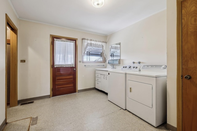 clothes washing area featuring separate washer and dryer, sink, crown molding, and cabinets