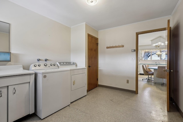 laundry area featuring crown molding, cabinets, and washer and dryer