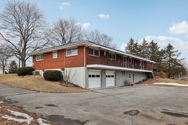 view of side of property with a garage and central air condition unit