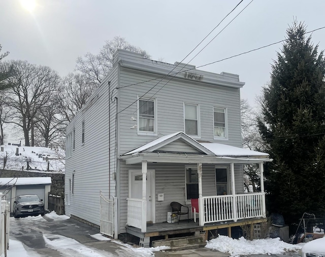 view of front of house with an outbuilding, a porch, and a garage