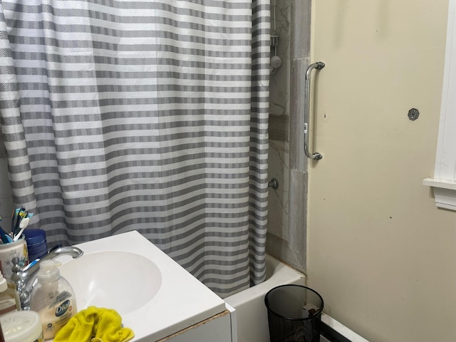 bathroom with shower / bath combination with curtain and sink