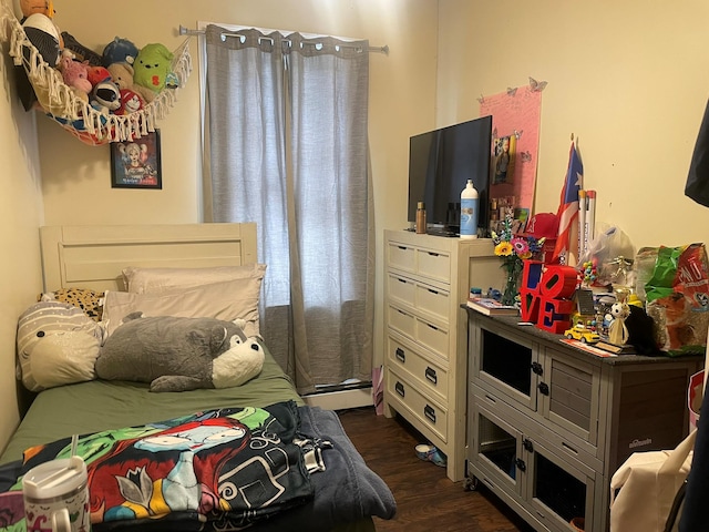 bedroom featuring baseboard heating and dark hardwood / wood-style flooring