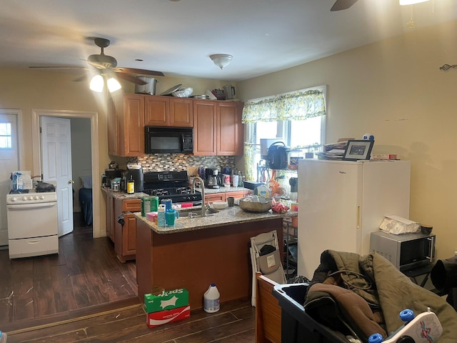 kitchen featuring dark wood-type flooring, light stone counters, ceiling fan, decorative backsplash, and black appliances