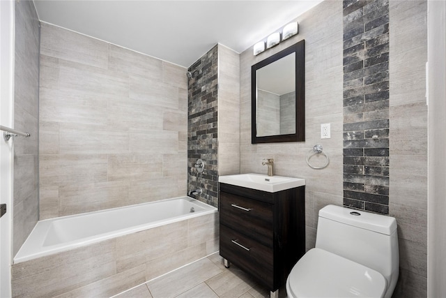 bathroom with tile patterned floors, vanity, toilet, and tile walls