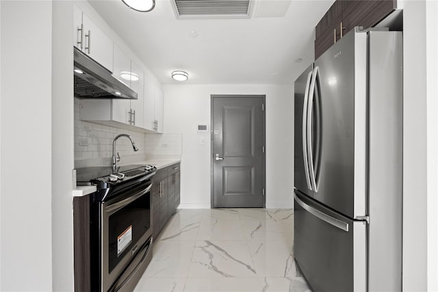 kitchen with backsplash, appliances with stainless steel finishes, dark brown cabinets, and white cabinets