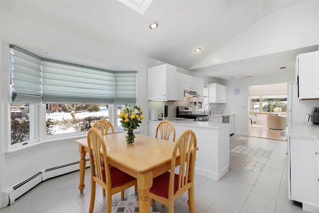 tiled dining room featuring a baseboard radiator, vaulted ceiling with skylight, and sink