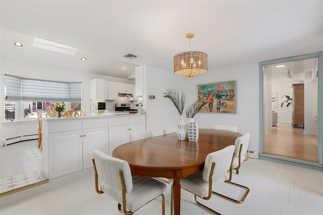 dining area featuring a notable chandelier, baseboard heating, and a skylight