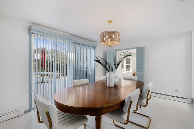 dining area featuring a baseboard heating unit and an inviting chandelier