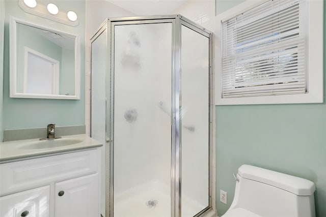 bathroom featuring walk in shower, vanity, and toilet