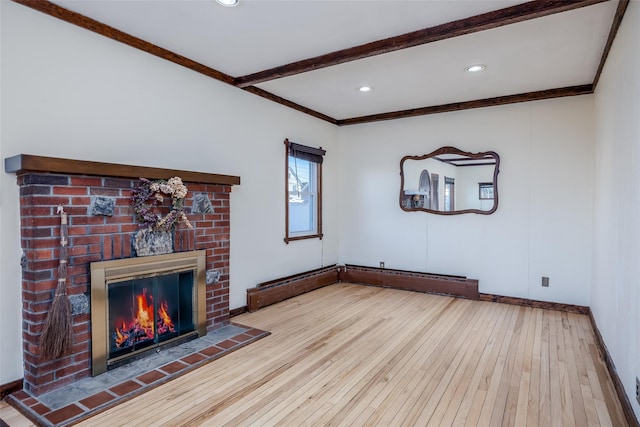 unfurnished living room featuring crown molding, a fireplace, light hardwood / wood-style floors, and beamed ceiling