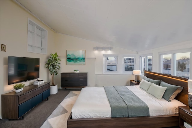 bedroom with dark carpet and vaulted ceiling