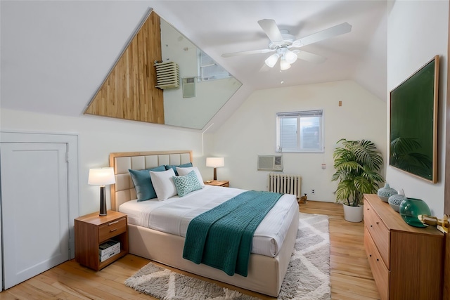 bedroom with lofted ceiling, radiator, ceiling fan, and light hardwood / wood-style flooring