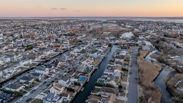 aerial view at dusk featuring a water view