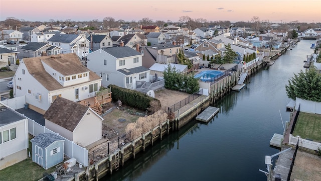 aerial view at dusk featuring a water view