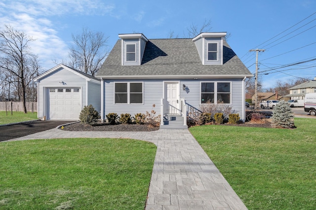 cape cod home with an outbuilding, a garage, and a front lawn